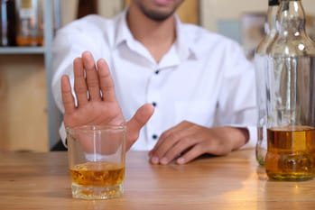 Мужчина отказывается от стакана с алкоголем
